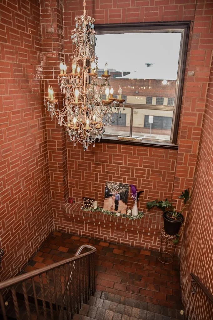 Historic brick stairwell and gold chandelier at Nineteen 25 Denver Private Event Venue